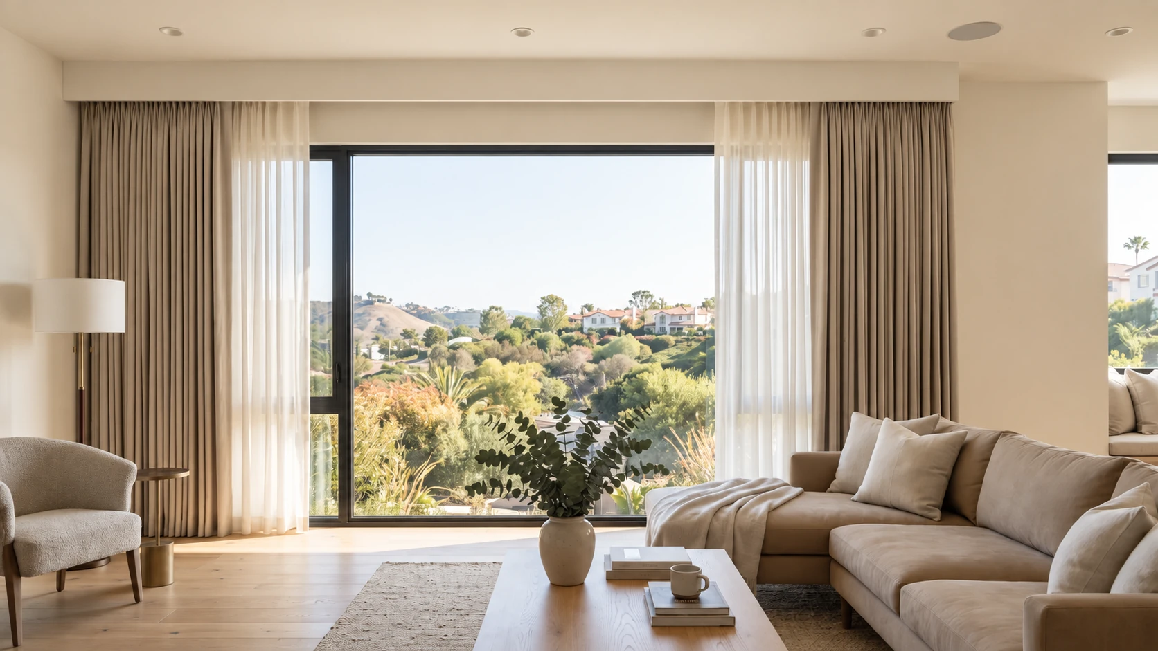 Layered curtains fully open beneath a concealed curtain box in a sunlit living room